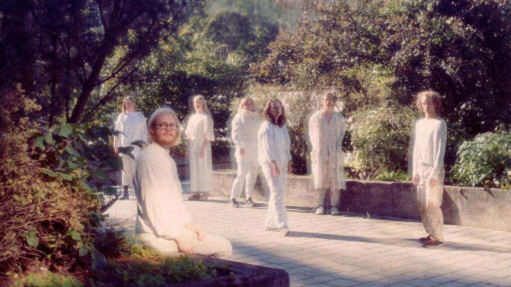 Ihmisiä valkoisissa vaatteissa puistossa